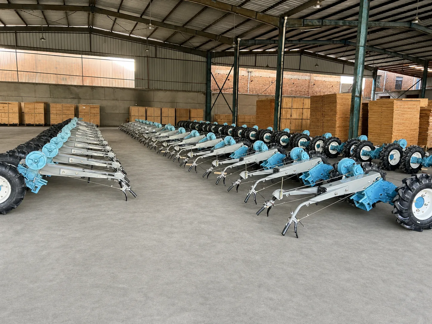 Rows of walking tractor chassis arranged inside a production workshop
